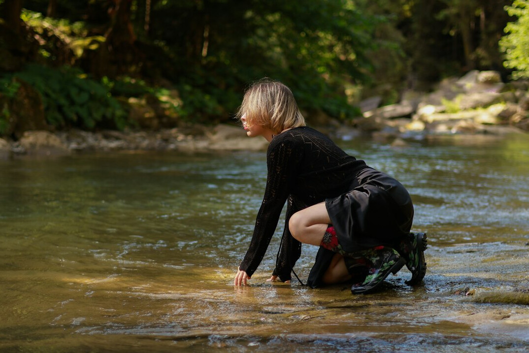 Researcher collecting a water sample from a river for testing