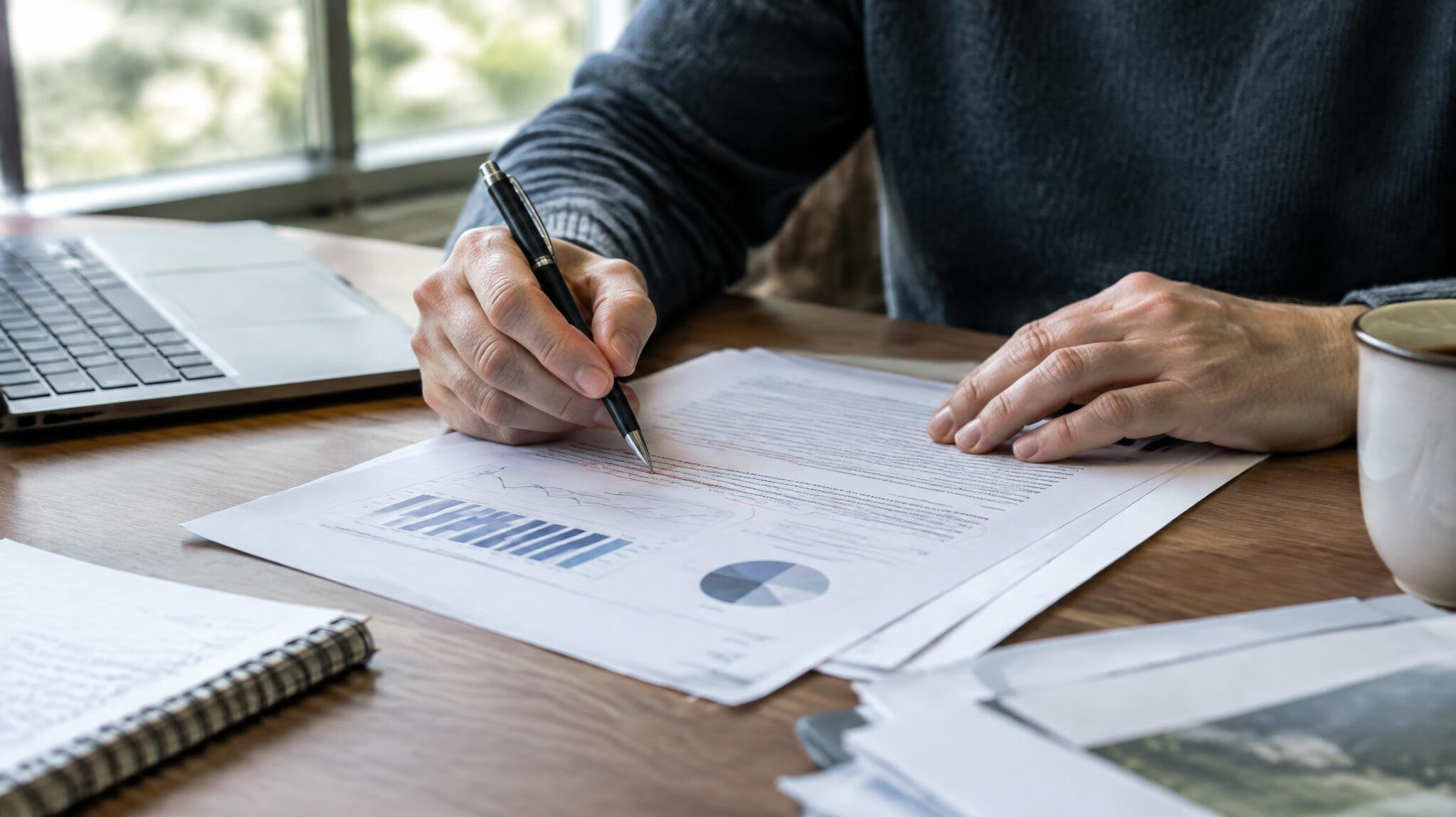 Journalist annotating printed documents with a pen at a desk
